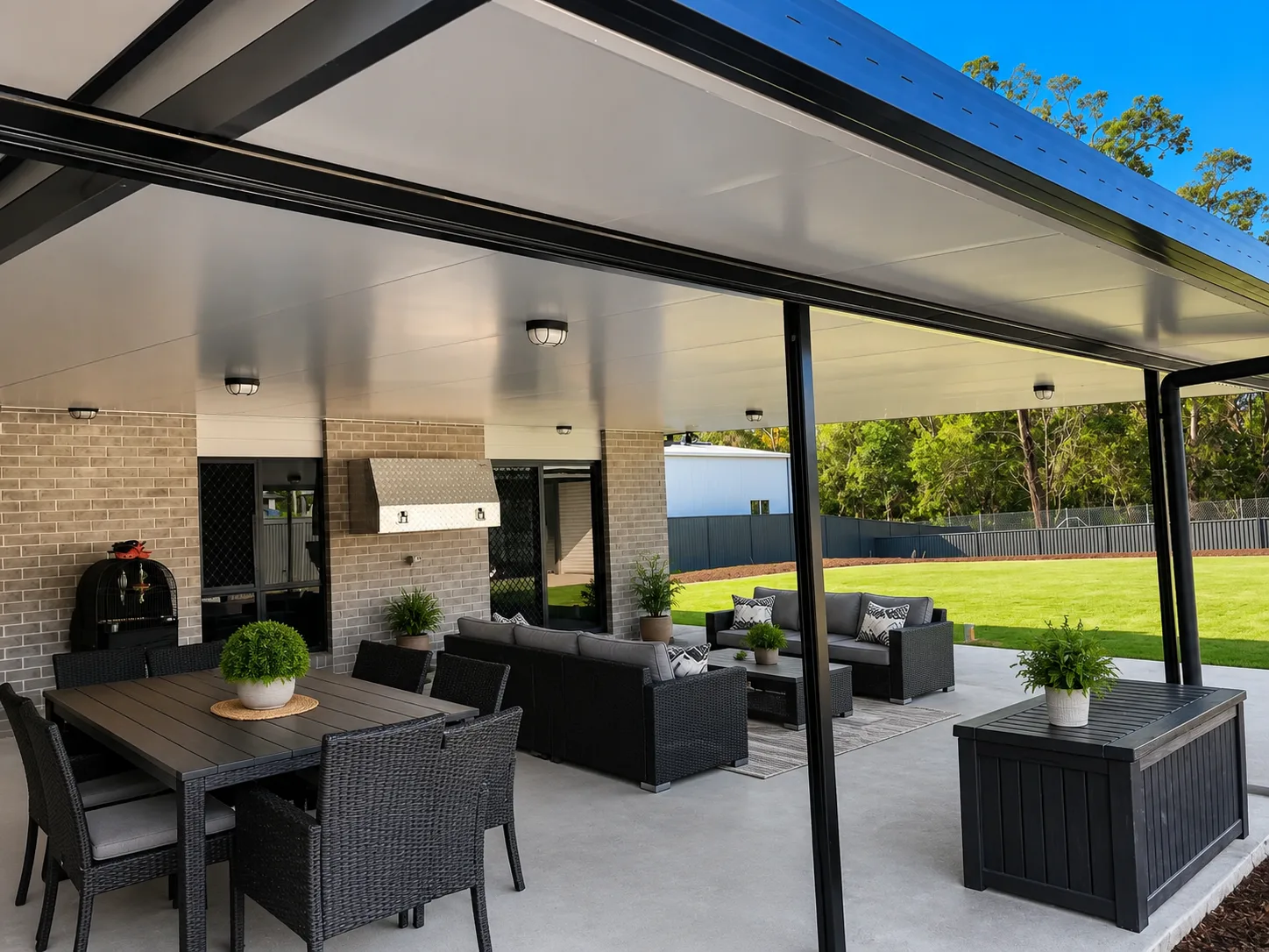 Underside of an insulated attached patio roof with downlights, over an outdoor dining and lounge setting